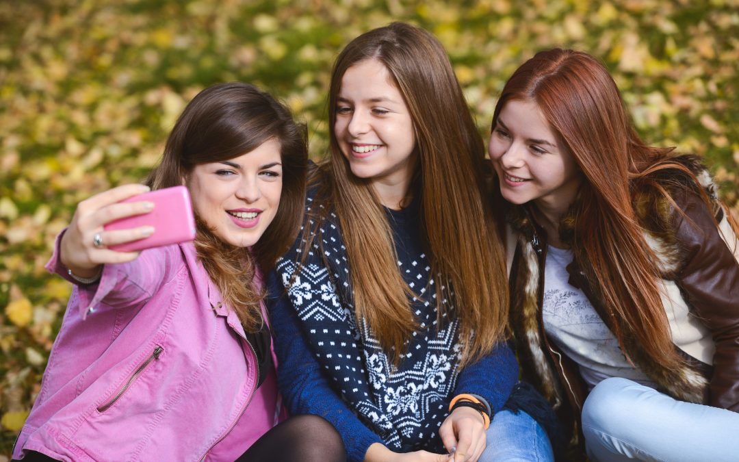 Three sisters taking a selfie in park